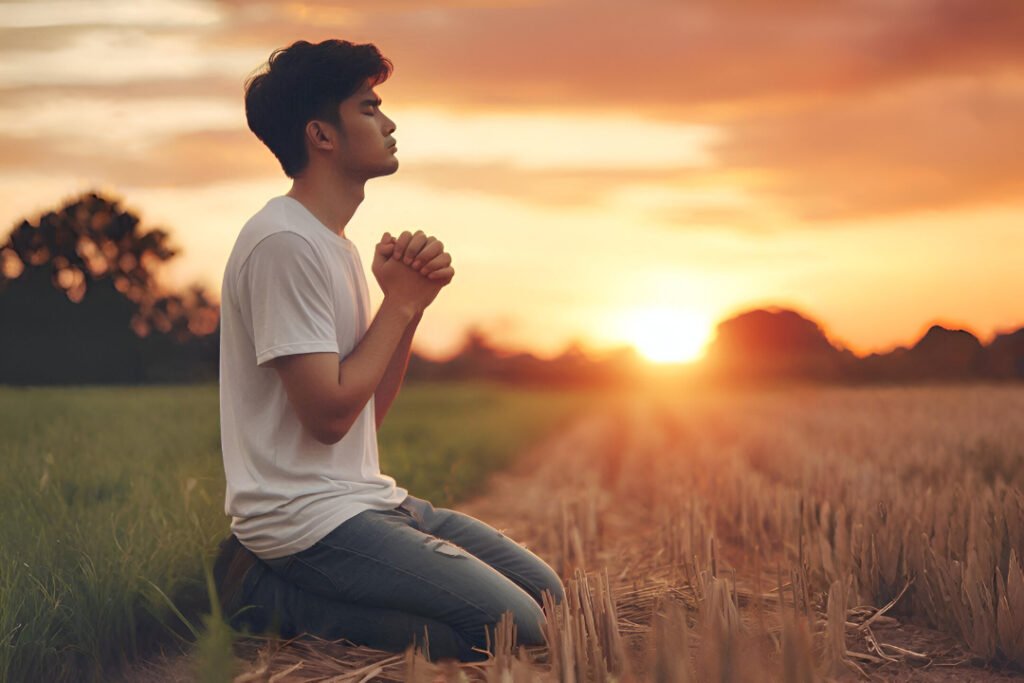 Pessoa orando ao pôr do sol, simbolizando arrependimento e perdão cristão